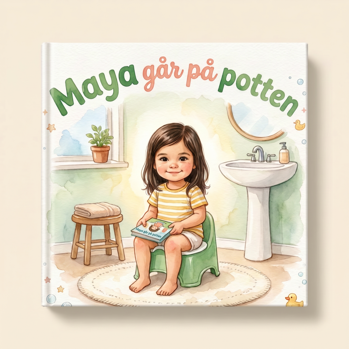Lukket bokmodell med illustrert forside til « Maya går på potten ».